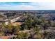 Aerial shot of the property situated among mature trees, with a highway and skyline visible in the background at 2107 Penrose Dr, Atlanta, GA 30344