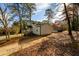 Exterior side view of house on lot with mature trees and long driveway at 2107 Penrose Dr, Atlanta, GA 30344
