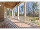 Expansive covered porch with exposed beams, white columns, and wood railing overlooking a wooded backyard at 305 Inman Pl, Roswell, GA 30075
