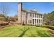 Stately brick home with multiple covered porches overlooking a well-manicured lawn and tiered landscaping at 305 Inman Pl, Roswell, GA 30075