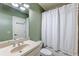 Bathroom features a shower-tub combo with white tile and a vanity with a large mirror and lighting at 305 Inman Pl, Roswell, GA 30075