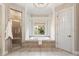 Inviting bathroom featuring a soaking tub, walk-in shower, and natural light at 305 Inman Pl, Roswell, GA 30075