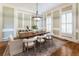 Bright dining room featuring a large wooden table, stylish chandelier and panel molding at 305 Inman Pl, Roswell, GA 30075