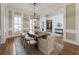 Well-lit dining room with a large wooden table, seating, and views into other rooms at 305 Inman Pl, Roswell, GA 30075