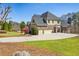 Traditional two-story home with a brick and siding exterior, three-car garage, and well-maintained landscaping at 305 Inman Pl, Roswell, GA 30075