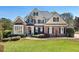 Beautiful brick home featuring manicured lawn, mature trees, and architectural design elements at 305 Inman Pl, Roswell, GA 30075