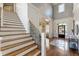 Bright foyer with hardwood floors, staircase, and paneled walls leading to additional living spaces at 305 Inman Pl, Roswell, GA 30075