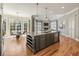 Kitchen island with a granite countertop and a wine rack plus seating with living room in the background at 305 Inman Pl, Roswell, GA 30075