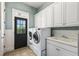 Functional laundry room with washer, dryer, sink, and ample cabinet space for storage at 305 Inman Pl, Roswell, GA 30075