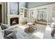Bright living room with fireplace, built-in shelving, and a cozy seating area overlooking a covered outdoor patio at 305 Inman Pl, Roswell, GA 30075