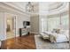 Main bedroom with hardwood floors, tray ceiling, and doorway to ensuite bathroom at 305 Inman Pl, Roswell, GA 30075
