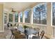Covered porch providing an outdoor dining space, ceiling fan, and a serene view of the surrounding trees at 305 Inman Pl, Roswell, GA 30075