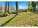 Grassy backyard view of the home and deck, nestled in a wooded setting providing privacy at 3819 Dora Se Dr, Smyrna, GA 30082