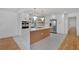 Bright, open kitchen with a large island, stainless appliances, wooden shelving and hardwood floors at 3819 Dora Se Dr, Smyrna, GA 30082