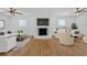 Spacious living room with hardwood floors, a brick fireplace, ceiling fans, and white furniture at 3819 Dora Se Dr, Smyrna, GA 30082
