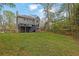 The spacious backyard has mature trees and a black deck with stairs on the side of the house at 4495 Sagebrush Nw Dr, Kennesaw, GA 30152