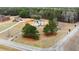 Aerial shot of the white home, expansive yard, surrounding homes, and lush green trees at 636 Ginger Cake Rd, Fayetteville, GA 30214