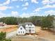 Aerial view of a grand, white multi-story home surrounded by lush green trees and a large yard at 636 Ginger Cake Rd, Fayetteville, GA 30214