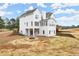 Backyard with tiered retaining walls, patio, deck, fire pit, and view of the multi-story white home at 636 Ginger Cake Rd, Fayetteville, GA 30214