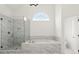 Bathroom featuring a marble tile shower and soaking tub with an arched window above at 636 Ginger Cake Rd, Fayetteville, GA 30214