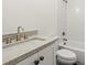 Bathroom with granite countertop, white cabinets, tub, and toilet at 636 Ginger Cake Rd, Fayetteville, GA 30214