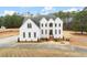 Stunning white brick two-story home with striking architectural details and a meticulously maintained lawn at 636 Ginger Cake Rd, Fayetteville, GA 30214