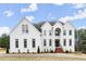 Elegant two-story white home with a prominent entrance and symmetrical window design, set against a bright sky at 636 Ginger Cake Rd, Fayetteville, GA 30214