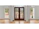Foyer with intricate wood double doors, hardwood floors, and elegant white columns at 636 Ginger Cake Rd, Fayetteville, GA 30214