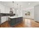 Modern kitchen with gray island, white cabinets, stainless steel appliances, and hardwood floors at 636 Ginger Cake Rd, Fayetteville, GA 30214