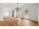 Bright living room with hardwood floors, arched doorway, modern chandelier, and large windows at 636 Ginger Cake Rd, Fayetteville, GA 30214