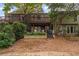 Townhome's back exterior with multiple decks, a stone retaining wall, and mature trees at 1088 Riverbend Club Se Dr, Atlanta, GA 30339