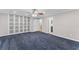 Spacious bedroom with blue carpet, a ceiling fan, and a closet storage system at 1088 Riverbend Club Se Dr, Atlanta, GA 30339