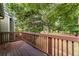 A wooden deck with brown railings overlooks a lush green backyard at 1088 Riverbend Club Se Dr, Atlanta, GA 30339