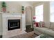 Inviting living room with a cozy fireplace and neutral decor with bright flowers and natural light from the window at 118 Cedarcrest Village Ct, Acworth, GA 30101