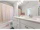 Modern bathroom with double vanity, bright lighting, and shower with patterned curtain at 2018 Manchester Ne St, Atlanta, GA 30324