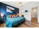Well-lit bedroom featuring a blue accent wall, a modern light fixture, and an ensuite bathroom at 2018 Manchester Ne St, Atlanta, GA 30324