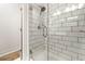 Modern bathroom shower featuring subway tile, a glass door, and chrome fixtures at 2018 Manchester Ne St, Atlanta, GA 30324
