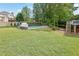 Spacious backyard with lush lawn, sparkling pool, and mature trees offering ample shade at 269 Hidden Wood Ct, Lawrenceville, GA 30043