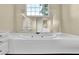 Bathroom featuring a large soaking tub under a window and a mirror, and white cabinets offering ample storage at 269 Hidden Wood Ct, Lawrenceville, GA 30043
