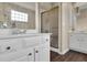 Bathroom featuring white vanity cabinets with warm brass hardware, a shower with glass doors, and neutral paint at 269 Hidden Wood Ct, Lawrenceville, GA 30043