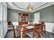 Charming dining room features elegant lighting, decorative wainscoting and a dining set at 269 Hidden Wood Ct, Lawrenceville, GA 30043