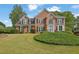 Beautiful brick home with well-manicured lawn, mature trees, and classic architectural details at 269 Hidden Wood Ct, Lawrenceville, GA 30043