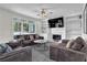 Spacious living room with a ceiling fan, fireplace, built-in shelves, and multiple sofas at 269 Hidden Wood Ct, Lawrenceville, GA 30043