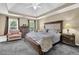 Spacious main bedroom featuring a tray ceiling, a comfortable king size bed, and two windows for natural light at 269 Hidden Wood Ct, Lawrenceville, GA 30043