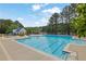 Large community pool with crystal clear water, plenty of space for swimming, and a lake in the background at 269 Hidden Wood Ct, Lawrenceville, GA 30043