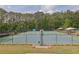 Well-maintained community tennis courts with a full perimeter fence and shaded benches for players to relax at 269 Hidden Wood Ct, Lawrenceville, GA 30043