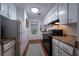 Well-lit galley kitchen with modern appliances, white cabinets, and wood-look flooring for easy maintenance at 3668 Kingsboro Ne Rd # 6, Atlanta, GA 30319