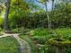 Serene backyard showcasing stone pathways, lush garden beds, and artistic water features at 1050 E Club Ne Ln, Atlanta, GA 30319