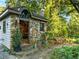 Charming stone guest house nestled amongst lush landscaping with a wooden bench and a decorative wrought iron fence at 1050 E Club Ne Ln, Atlanta, GA 30319