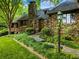 This stone home has beautiful landscaping and grass, and an inviting entryway at 1050 E Club Ne Ln, Atlanta, GA 30319